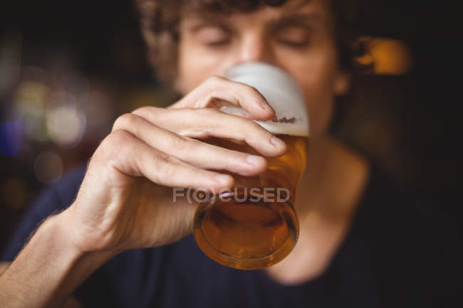 Чоловік має келих пива в барі — стокове фото