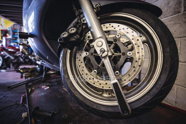 Primer plano de la rueda de la motocicleta en taller - foto de stock
