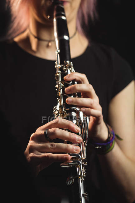 A meio da seção da mulher tocando um clarinete na escola de música — Fotografia de Stock