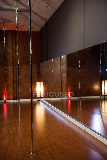Interno della moderna sala da ballo per la pole dance con luce e specchio — Foto stock