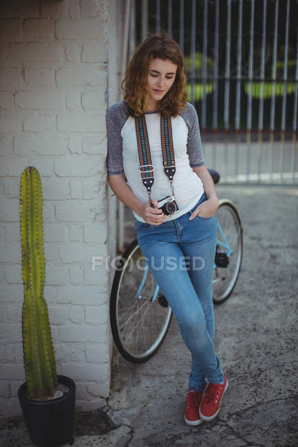 Beautiful woman leaning on wall with vintage camera — Stock Photo