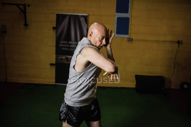 Guapo boxeador deportivo tailandés practicando boxeo en el gimnasio - foto de stock
