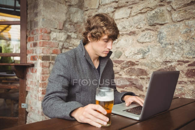 Mann benutzte Laptop an Bar — Stockfoto