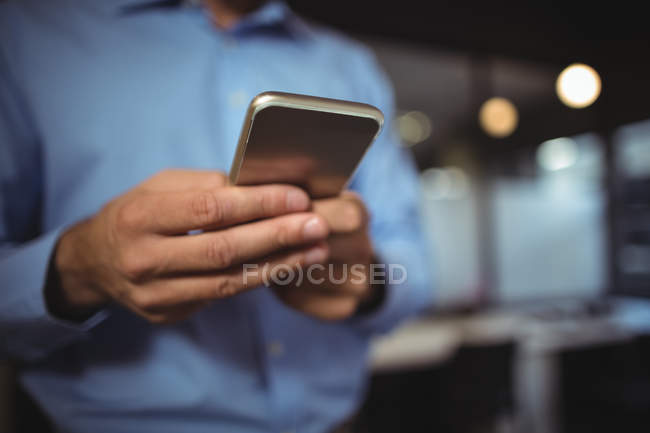 Середина бізнесмена, що використовує мобільний телефон в офісі — стокове фото