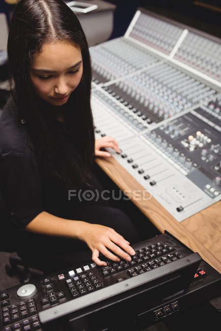 Estudiante usando mezclador de sonido en un estudio - foto de stock