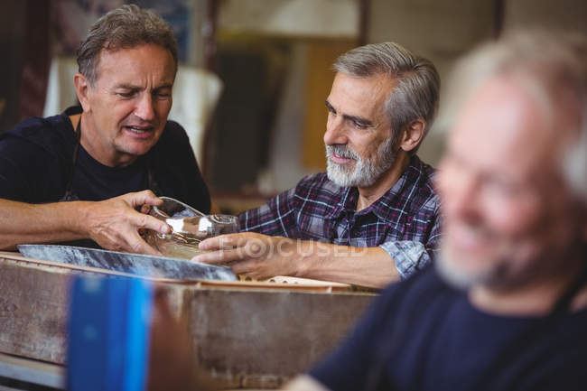 Glassblowers colleagues looking at glassware at glassblowing factory — Stock Photo