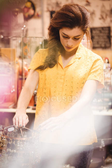 Woman looking at vintage jewellery in antique shop — Stock Photo