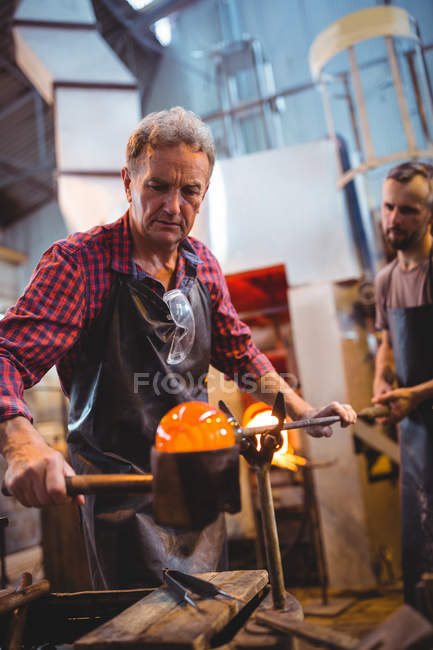 Glassblowers forming and shaping a molten glass at glassblowing factory — Stock Photo
