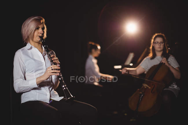 Tre studentesse che suonano contrabbasso, clarinetto e pianoforte in uno studio — Foto stock