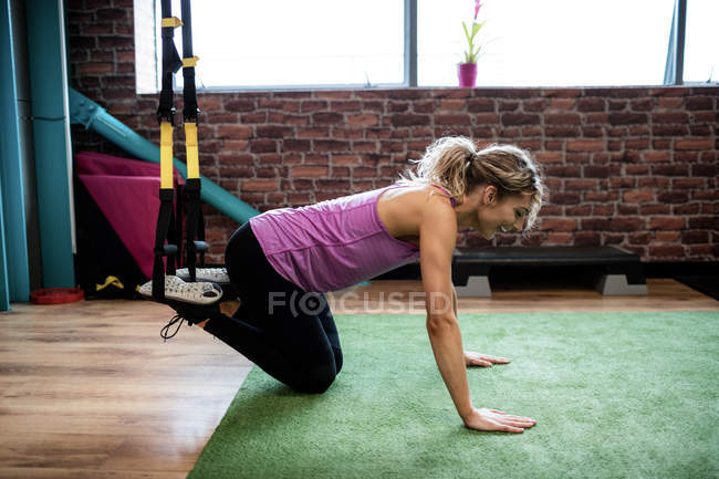 Mujer haciendo ejercicio con banda de resistencia en el gimnasio - foto de stock