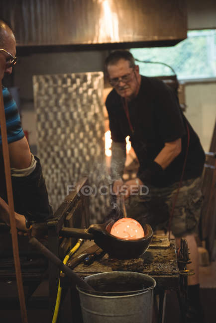 Team of glassblowers forming and shaping molten glass at glassblowing factory — Stock Photo