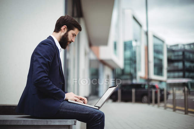 Aufmerksamer Geschäftsmann benutzt Laptop außerhalb des Büros — Stockfoto