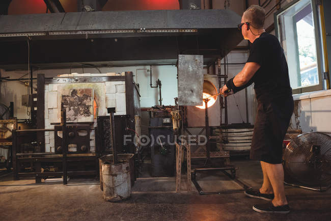 Verre chauffant de souffleur de verre dans le four à l'usine de soufflage de verre — Photo de stock