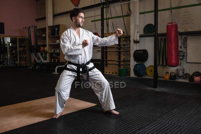 Bell'uomo che pratica karate in palestra — Foto stock