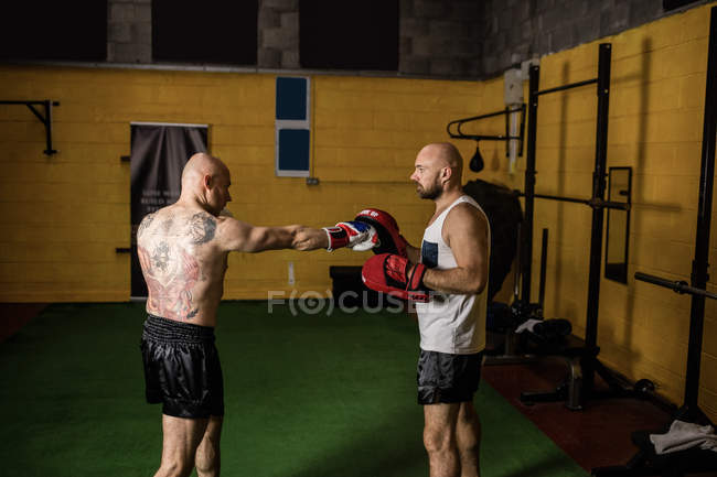 Vista lateral de dois boxers tailandeses praticando no ginásio — Fotografia de Stock