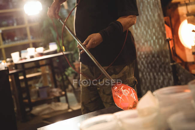 Souffleur de verre façonnant le verre fondu à l'usine de soufflage de verre — Photo de stock