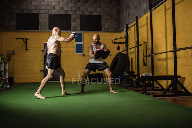 Boxeadores tailandeses practicando boxeo en gimnasio oscuro - foto de stock