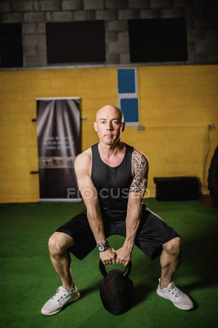 Apuesto atlético deportista levantamiento de peso en el gimnasio - foto de stock