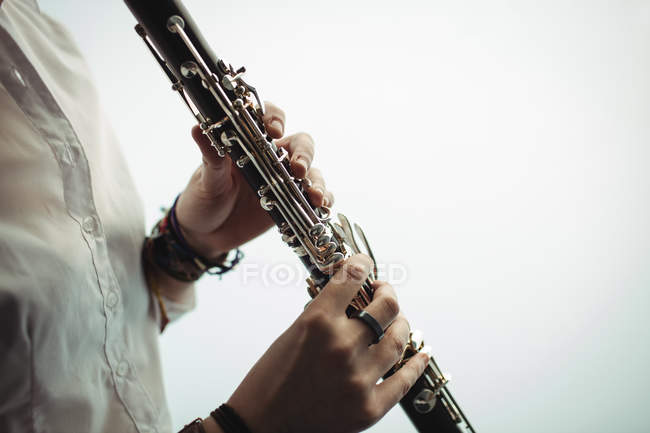 A meio da seção da mulher tocando um clarinete na escola de música — Fotografia de Stock