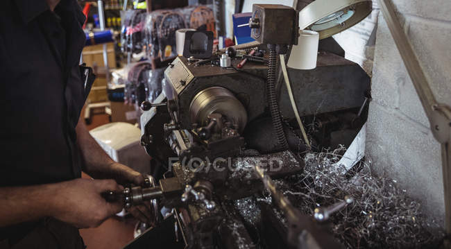 Mechanic working on industrial lathe machine in workshop — Stock Photo