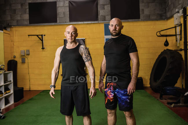 Retrato de dos boxeadores tailandeses confiados de pie en el gimnasio - foto de stock