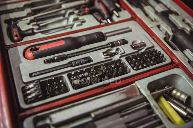 Herramientas de automóvil dispuestas en caja de herramientas en el taller - foto de stock