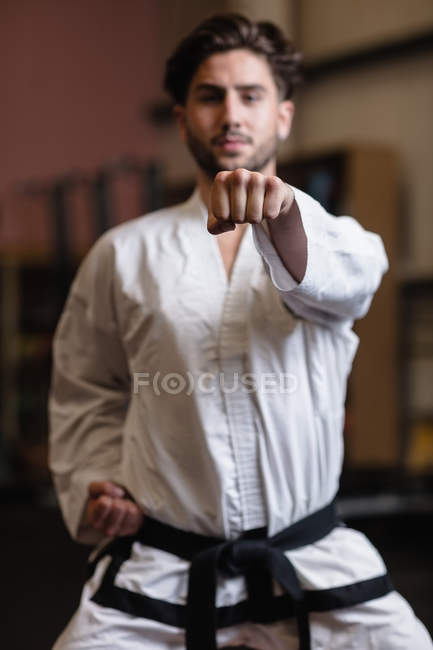 Enfoque selectivo del hombre practicando karate en el gimnasio - foto de stock