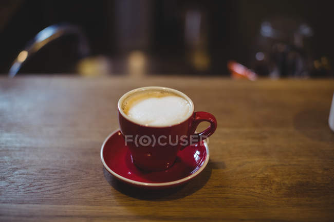 Cup of cappuccino on table in bicycle shop — Stock Photo