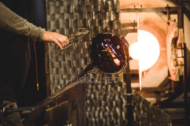 Ventilador que forma el vidrio fundido en la fábrica de soplado de vidrio - foto de stock