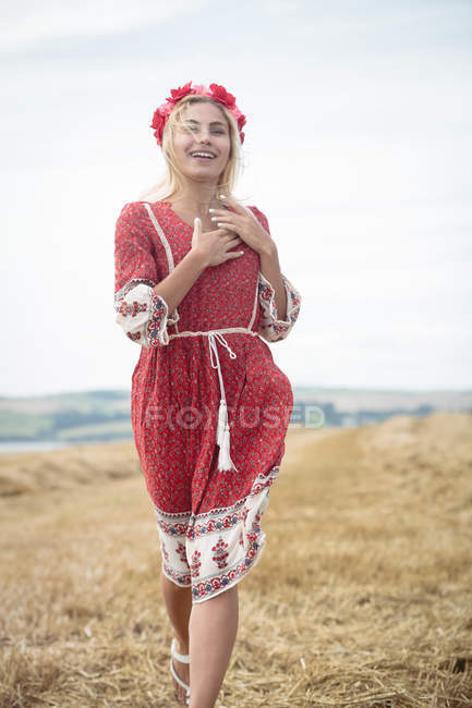 Femme blonde insouciante marchant dans le champ — Photo de stock
