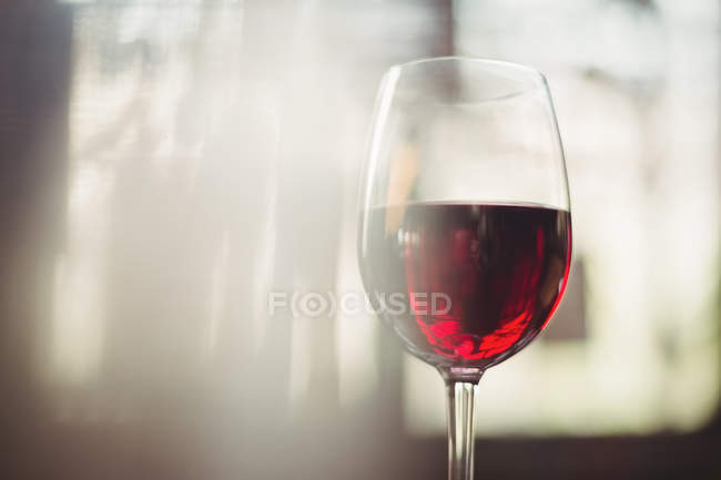 Primo piano di vetro con vino rosso in tavola al bar — Foto stock