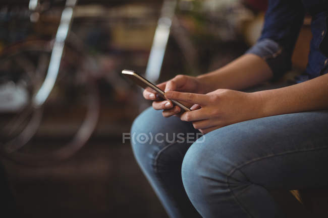 Mid section woman using mobile phone in workshop — Stock Photo