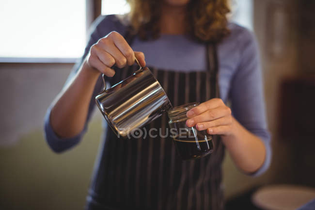 Seção média de garçonete preparando café no balcão na oficina — Fotografia de Stock