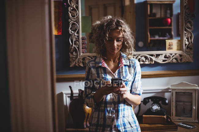 Bella donna che utilizza il telefono cellulare a casa — Foto stock