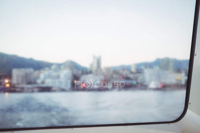 Vista borrosa de la ciudad portuaria desde el cristal de la ventana - foto de stock