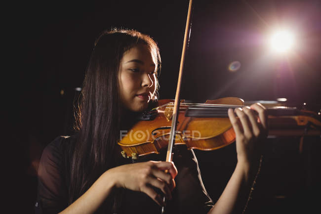 Estudiante tocando el violín en un estudio - foto de stock