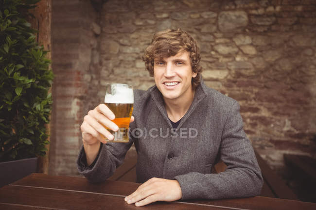 Portrait of man holding glass of beer in bar — Stock Photo