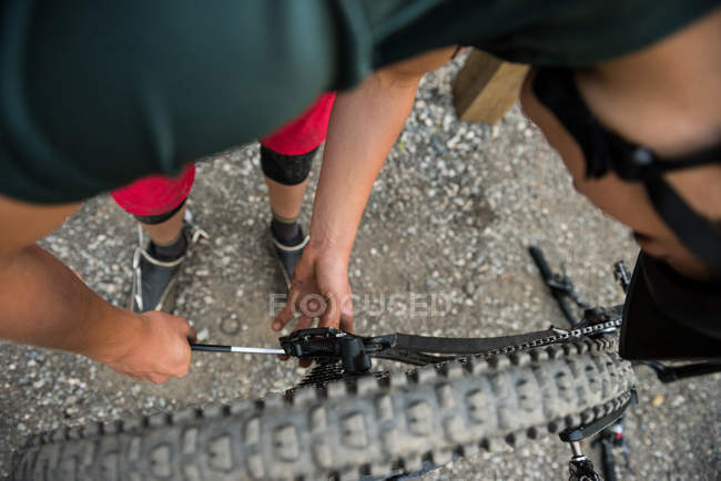 Чоловічий велосипедист ремонту свій велосипед в лісі на сонячний день — стокове фото