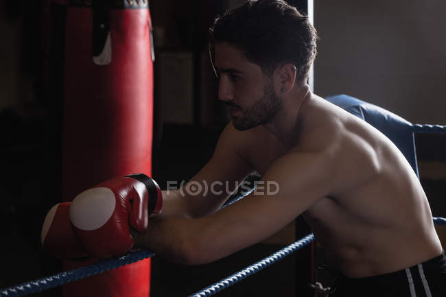 Tired boxer taking break after practice in fitness studio — Stock Photo