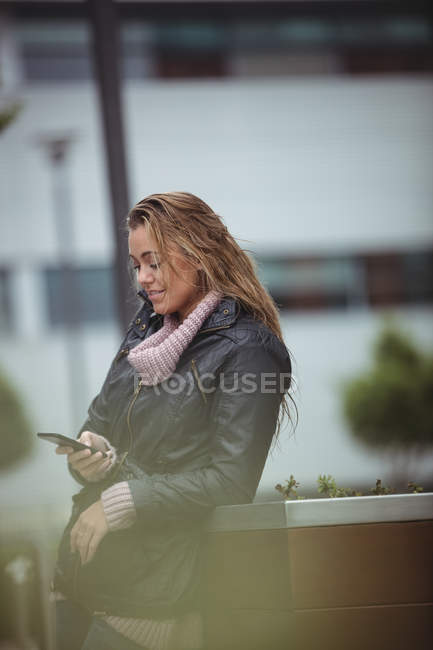Belle femme utilisant un smartphone dans la rue — Photo de stock