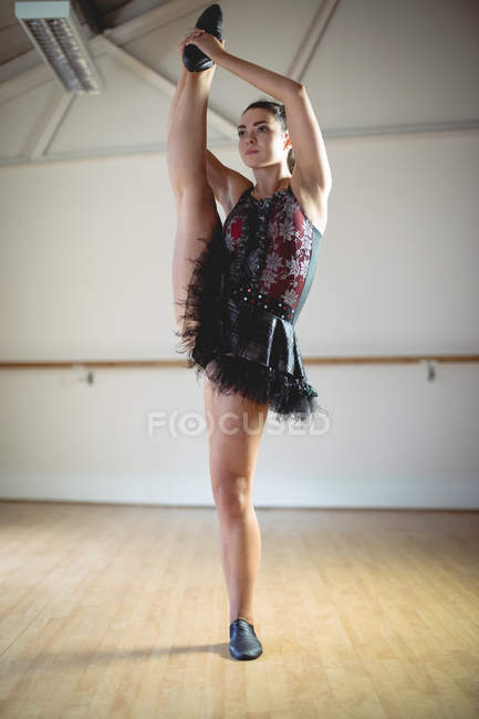 Bajo ángulo vista de bailarina en tutú oscuro bailando en estudio - foto de stock