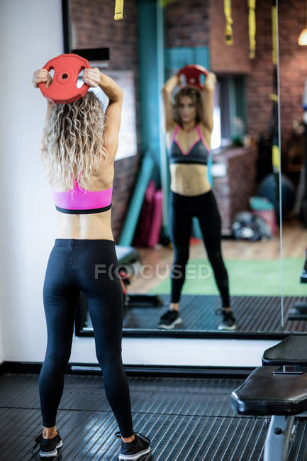 Spiegelbild der schönen Frau, die im Fitnessstudio trainiert — Stockfoto