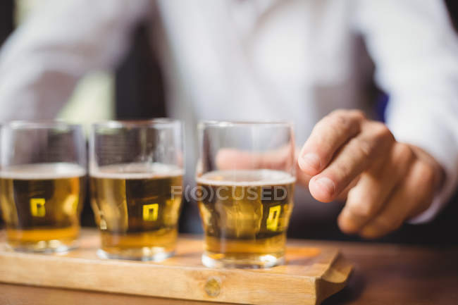 Крупный план бармена, держащего стакан виски у стойки бара в баре — стоковое фото