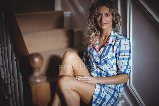 Retrato de mulher bonita sentada na escada em casa — Fotografia de Stock