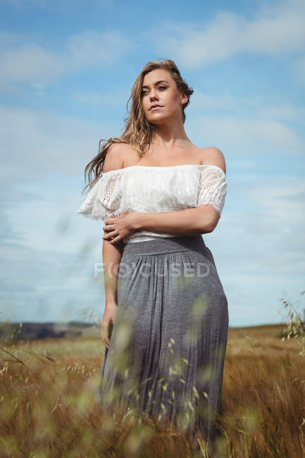 Frau steht an sonnigem Tag auf dem Land im Weizenfeld — Stockfoto