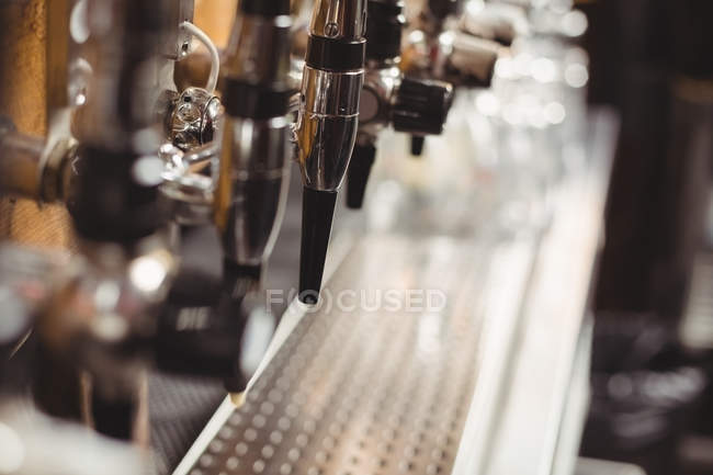 Primo piano della pompa della birra di fila al bar — Foto stock
