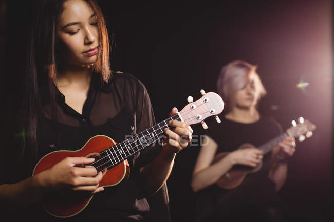 Mulheres bonitas tocando guitarra na escola de música — Fotografia de Stock