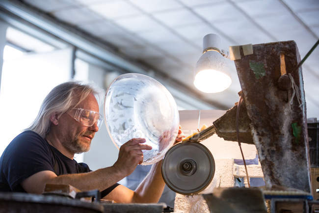 Soffiatore di vetro che lavora su un vetro alla fabbrica di soffiaggio del vetro — Foto stock