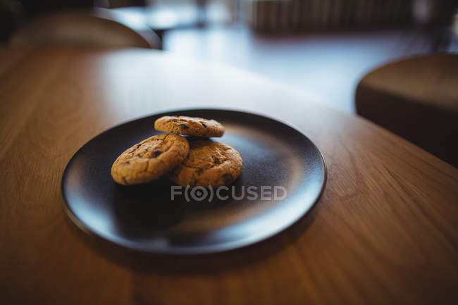 Three cookies in plate at cafeteria — Stock Photo