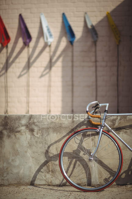 Bicicleta apoyada contra la pared en un día soleado - foto de stock